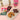 Assorted snacks including a cookie, chocolate bars, and a package on a pink surface with a cup.