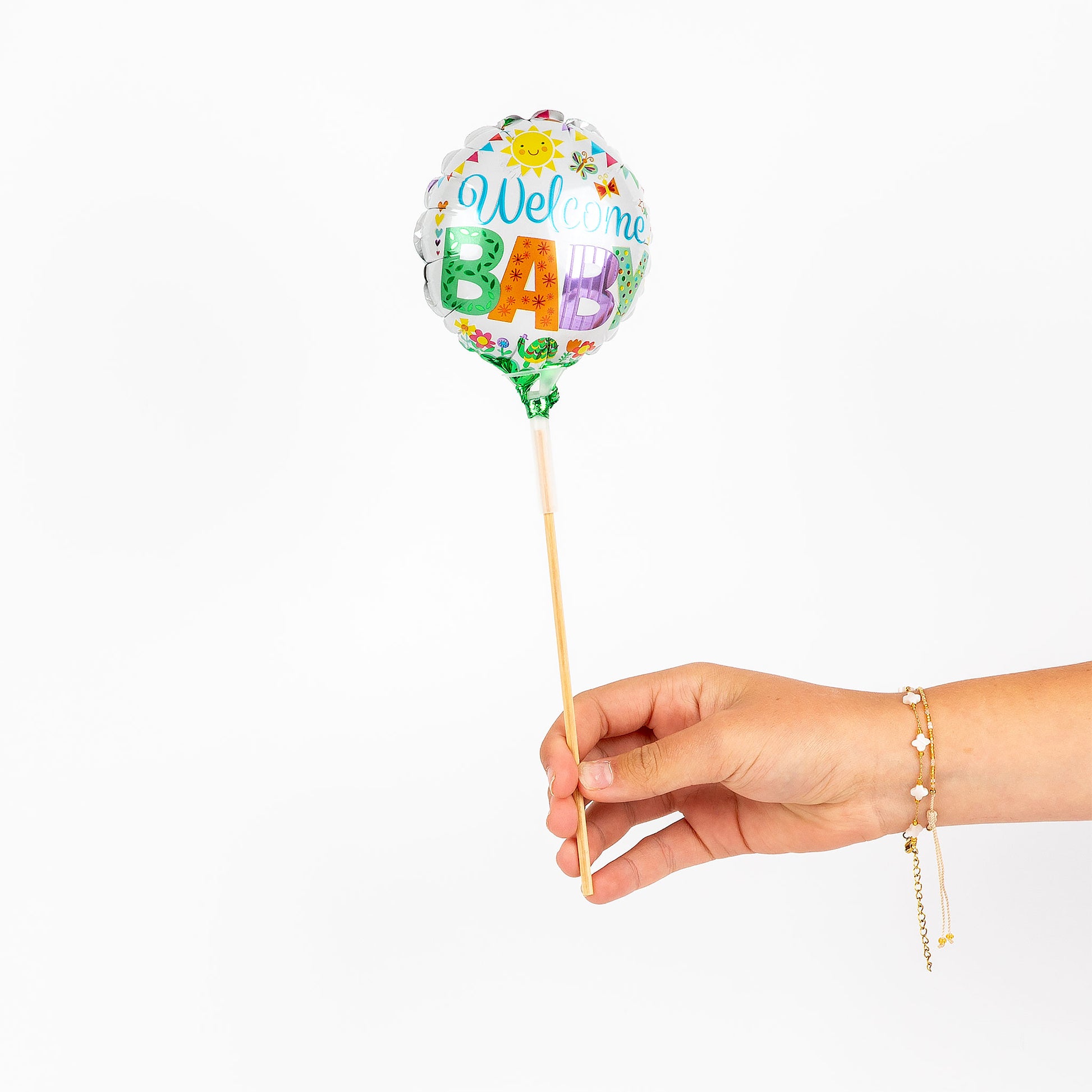 Hand holding a balloon with 'Welcome Baby' text on a white background