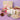 Gourmet gift basket with candles, cookies, and other treats on a purple surface