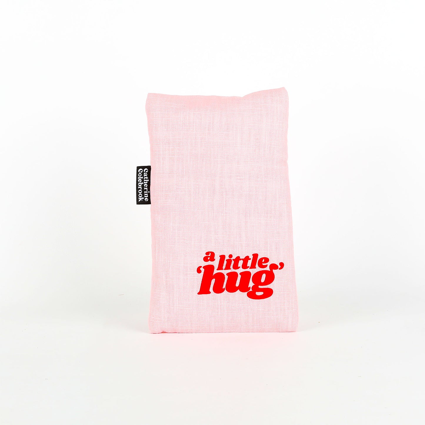 Pink heat pack with 'a little hug' text on a white background
