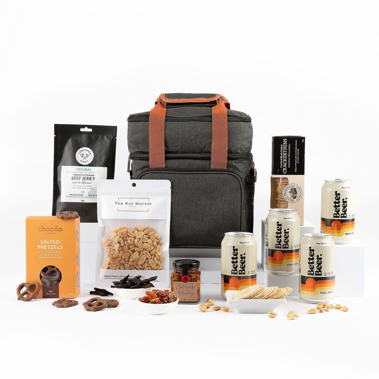 Gourmet gift set with a cooler bag, snacks, and beer on a white background