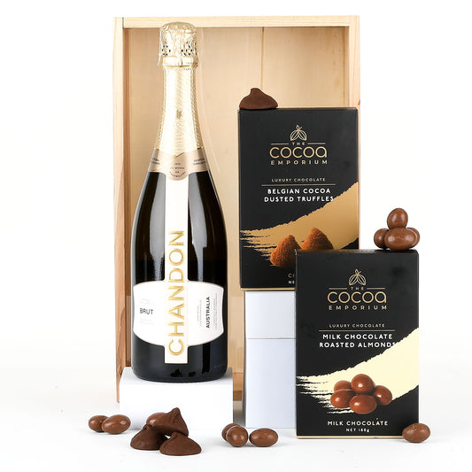 Bottle of Chandon champagne with Milk Chocolate Roasted Almonds and Belgian Cocoa Dusted Truffles in a wooden crate.