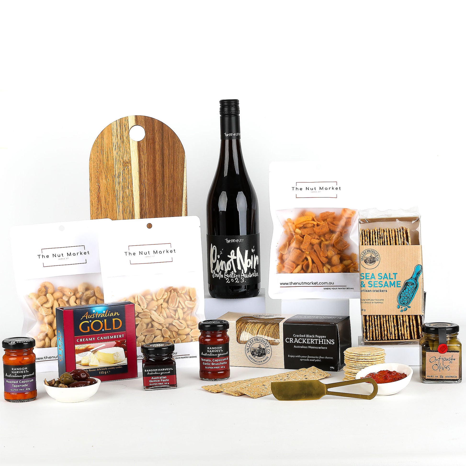 Assorted food items including a bottle of wine, nuts, crackers, spreads & a cheese board on a white background.