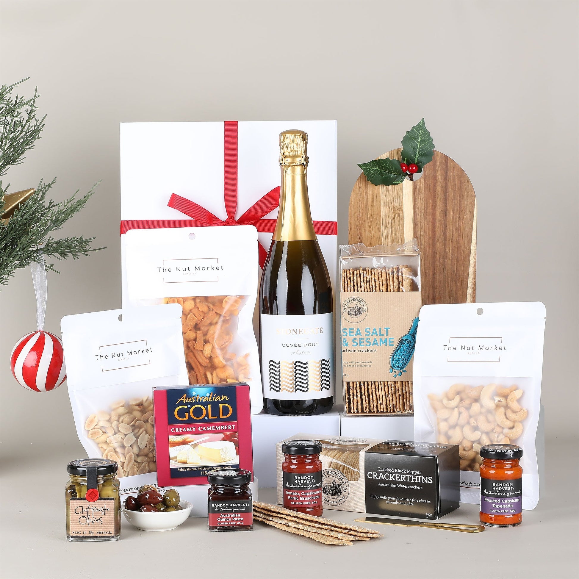 Gift basket with wine, snacks, and other items on a neutral background
