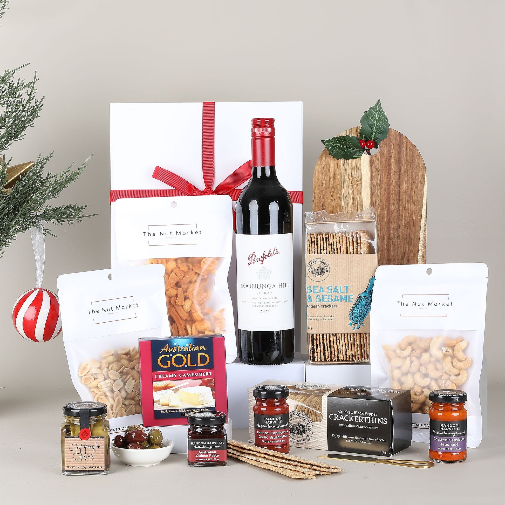 Gourmet gift basket with wine, snacks, and crackers on a neutral background