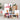 Assorted food items including a bottle of wine, nuts, and condiments on a neutral background.