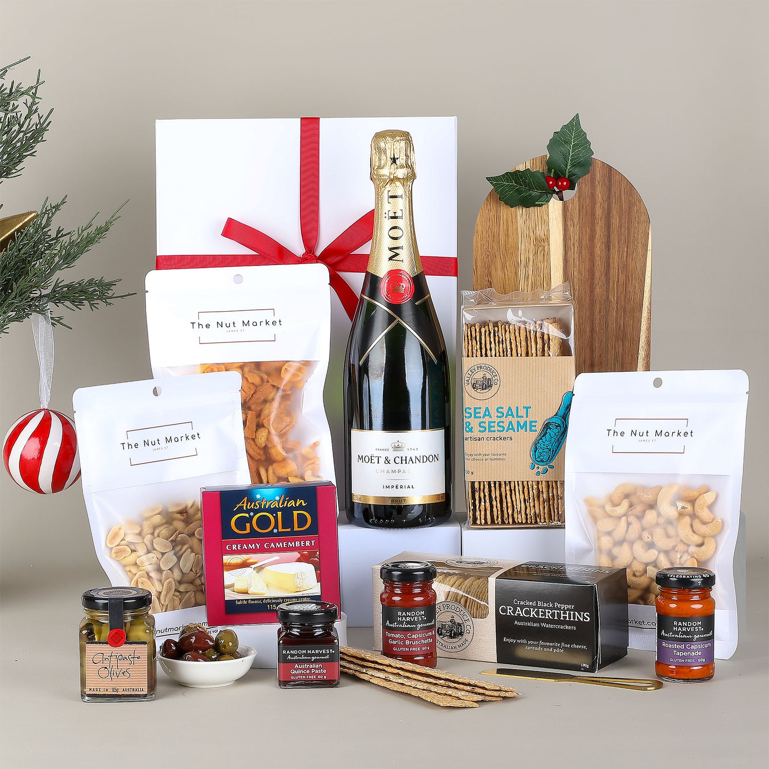 Gift basket with wine, snacks, and other items on a neutral background