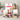Assorted food items including nuts, cheese, condiments & a serving board on a neutral background