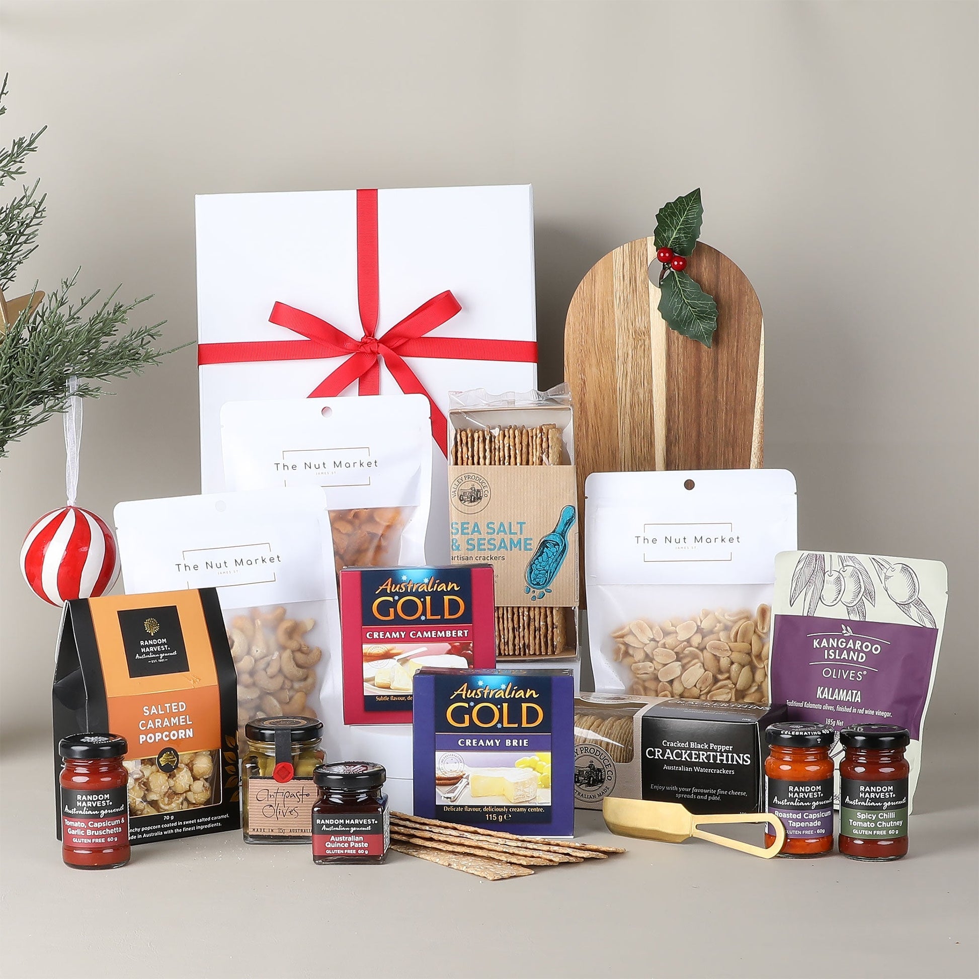 Assorted food products including dips, snacks, and a gift box with a red ribbon on a neutral background.