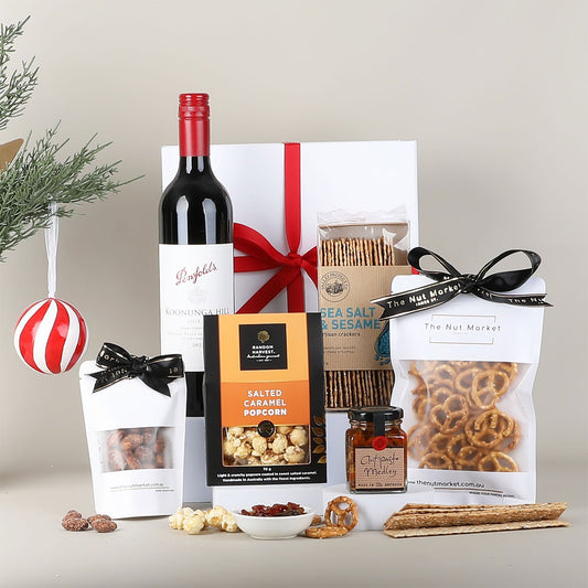 Gift basket with wine & snacks on a neutral background