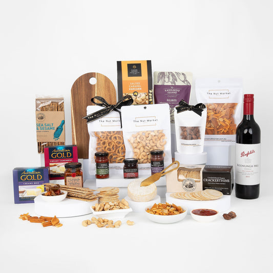 Assorted food products including wine, nuts, and spreads on a white surface.