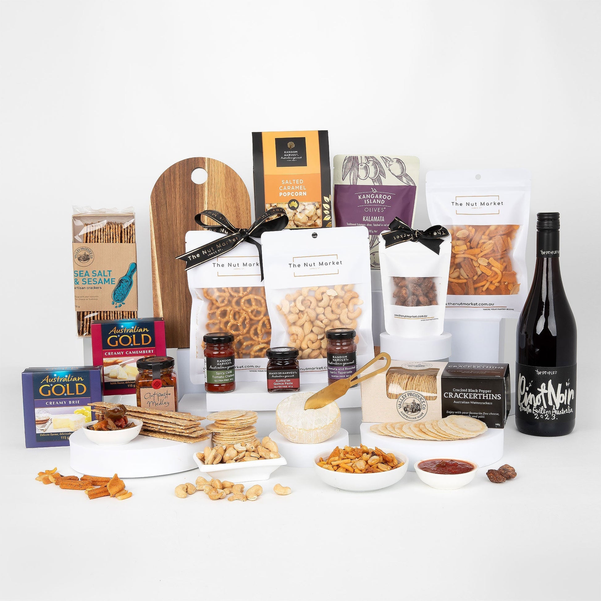 Assorted food items including nuts, crackers, and a bottle of wine on a white background
