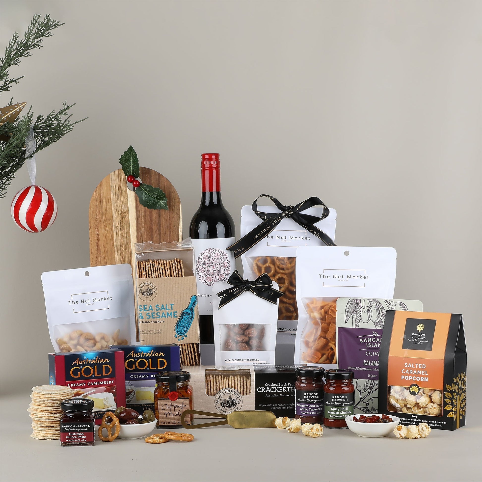 Assorted gourmet food items including wine, snacks, and crackers on a neutral background.