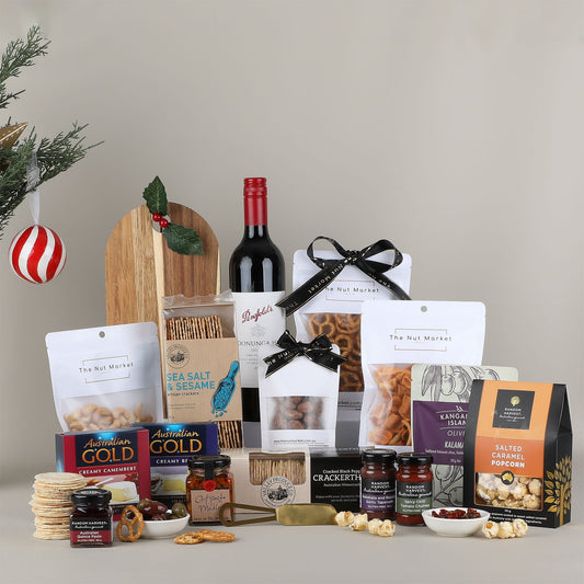 Assorted gourmet food items including wine, snacks, and crackers on a neutral background.