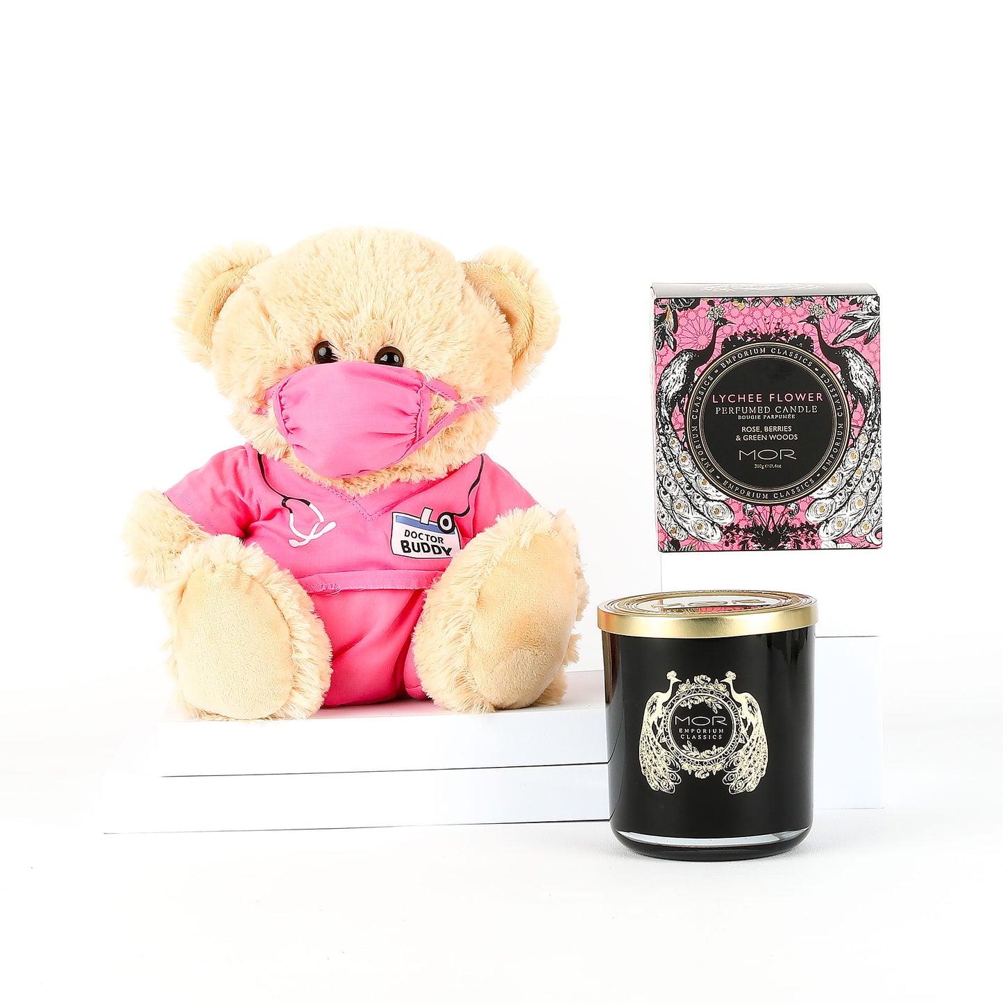 Teddy bear in pink scrubs with a mask and MOR candle on a white background
