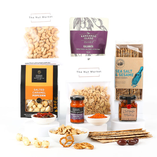 Assorted snacks including nuts, popcorn, olives, and crackers on a white background.