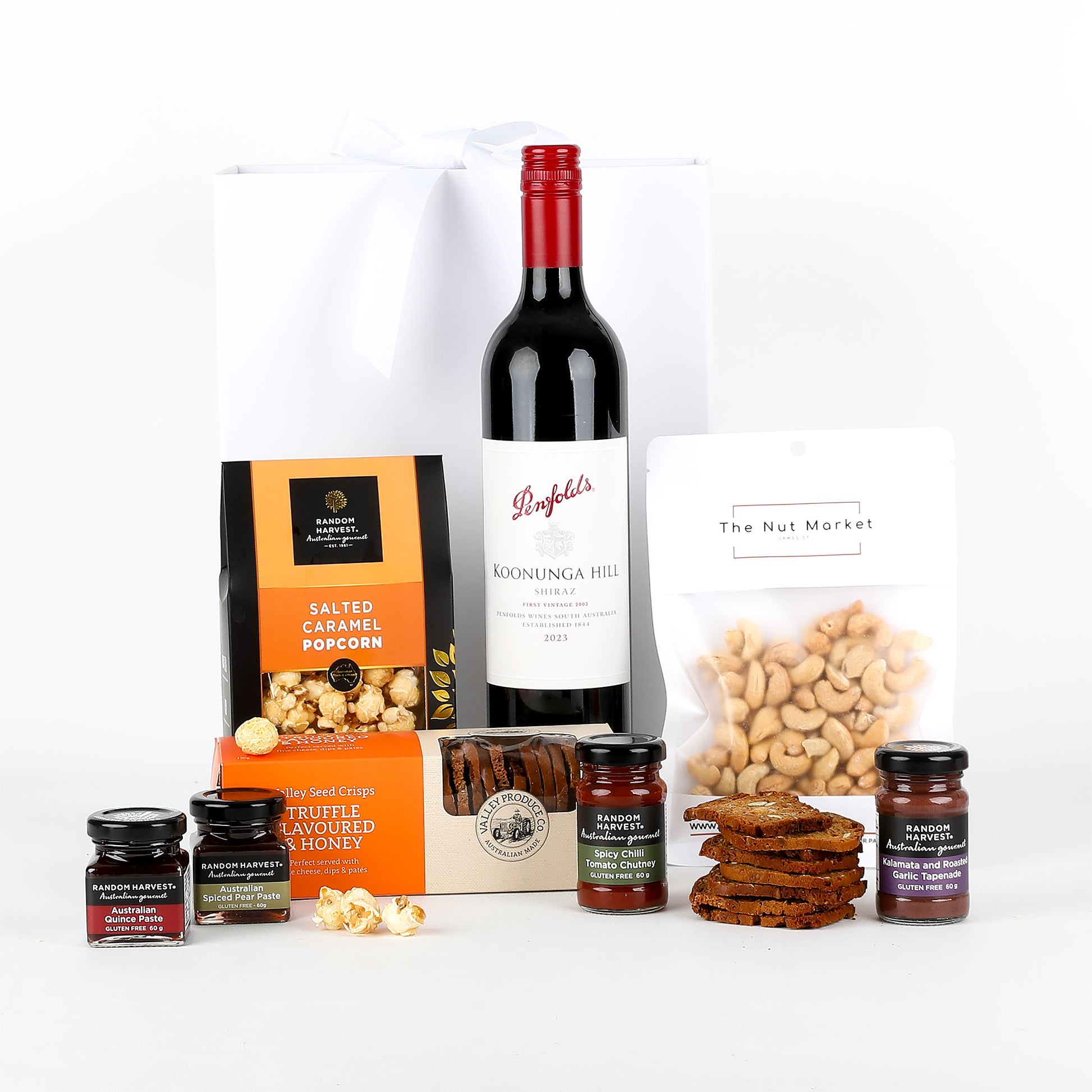 Penfolds wine bottle with popcorn, nuts, and other snacks on a white background