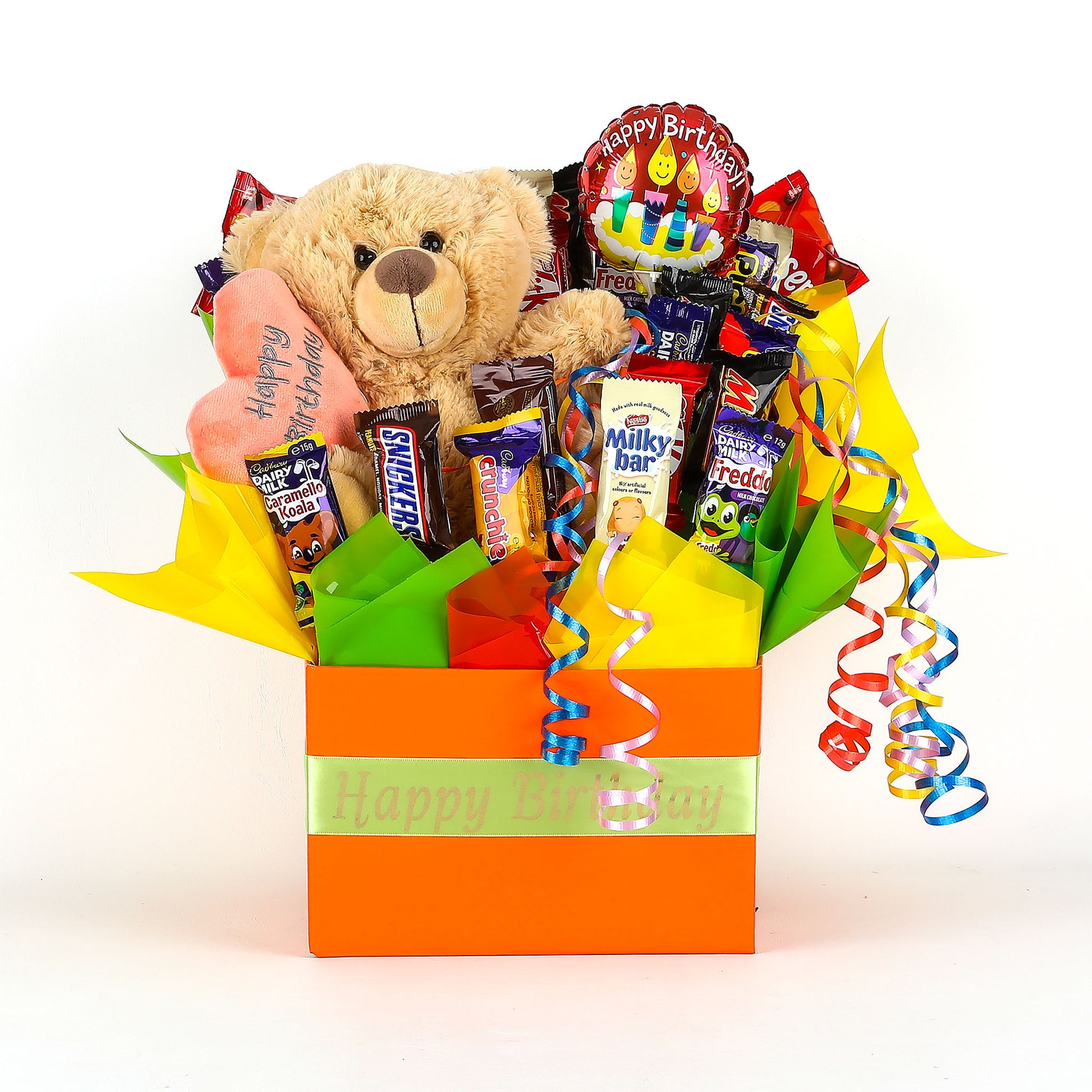 Gift basket with teddy bear, chocolates, and balloon labeled 'Happy Birthday' on a white background