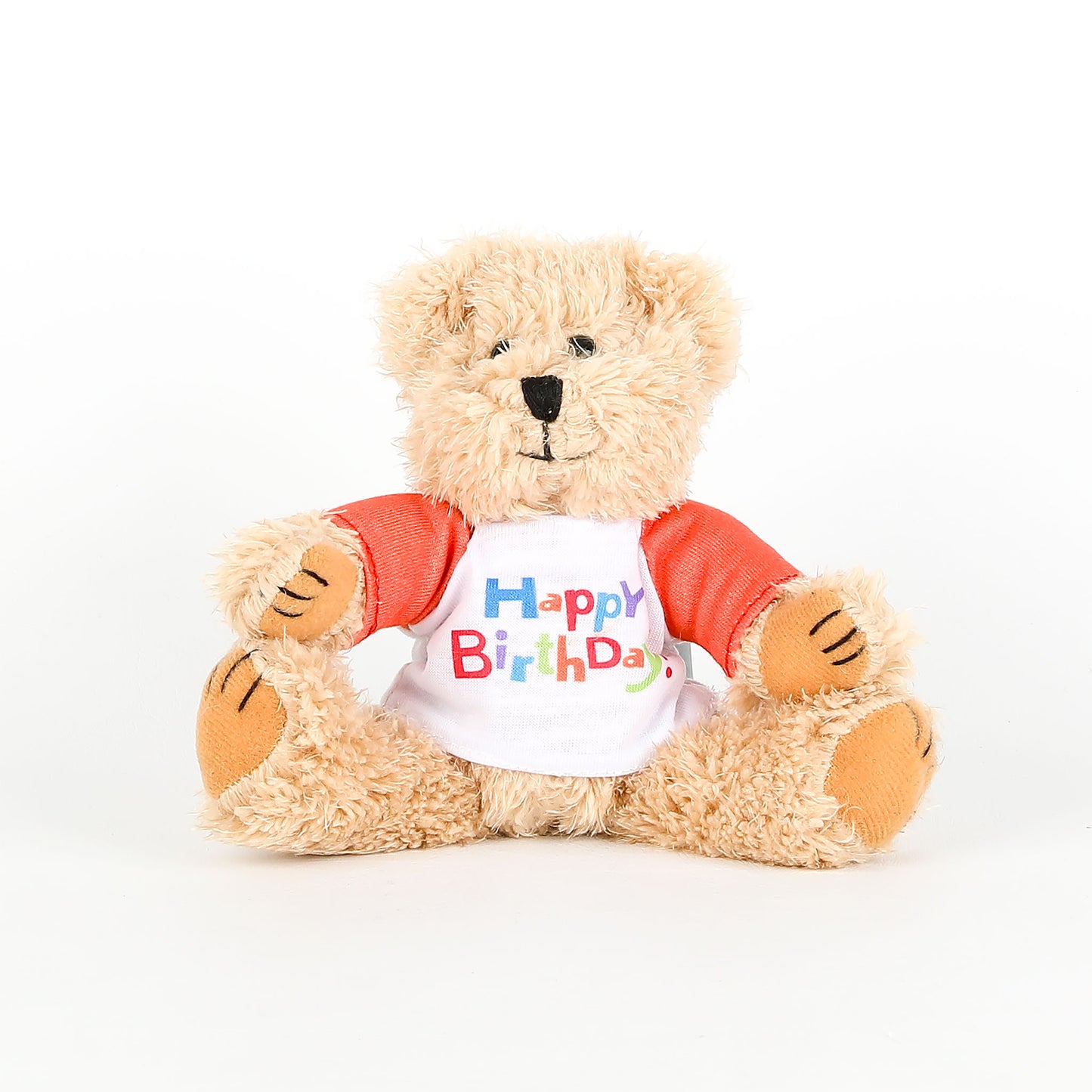Plush teddy bear wearing a 'Happy Birthday' shirt on a white background