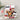 Assorted gourmet food items including pretzels, popcorn, and other snacks on a neutral background.