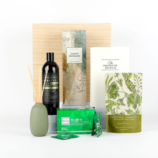 Collection of wellness products including a diffuser, body scrub, and tea packages on a white background