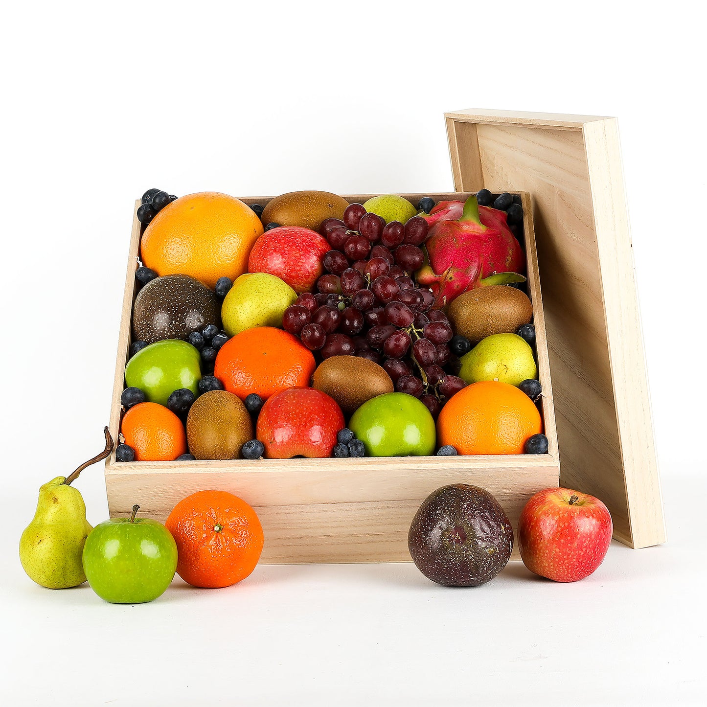Assorted fruits in a wooden box on a white background