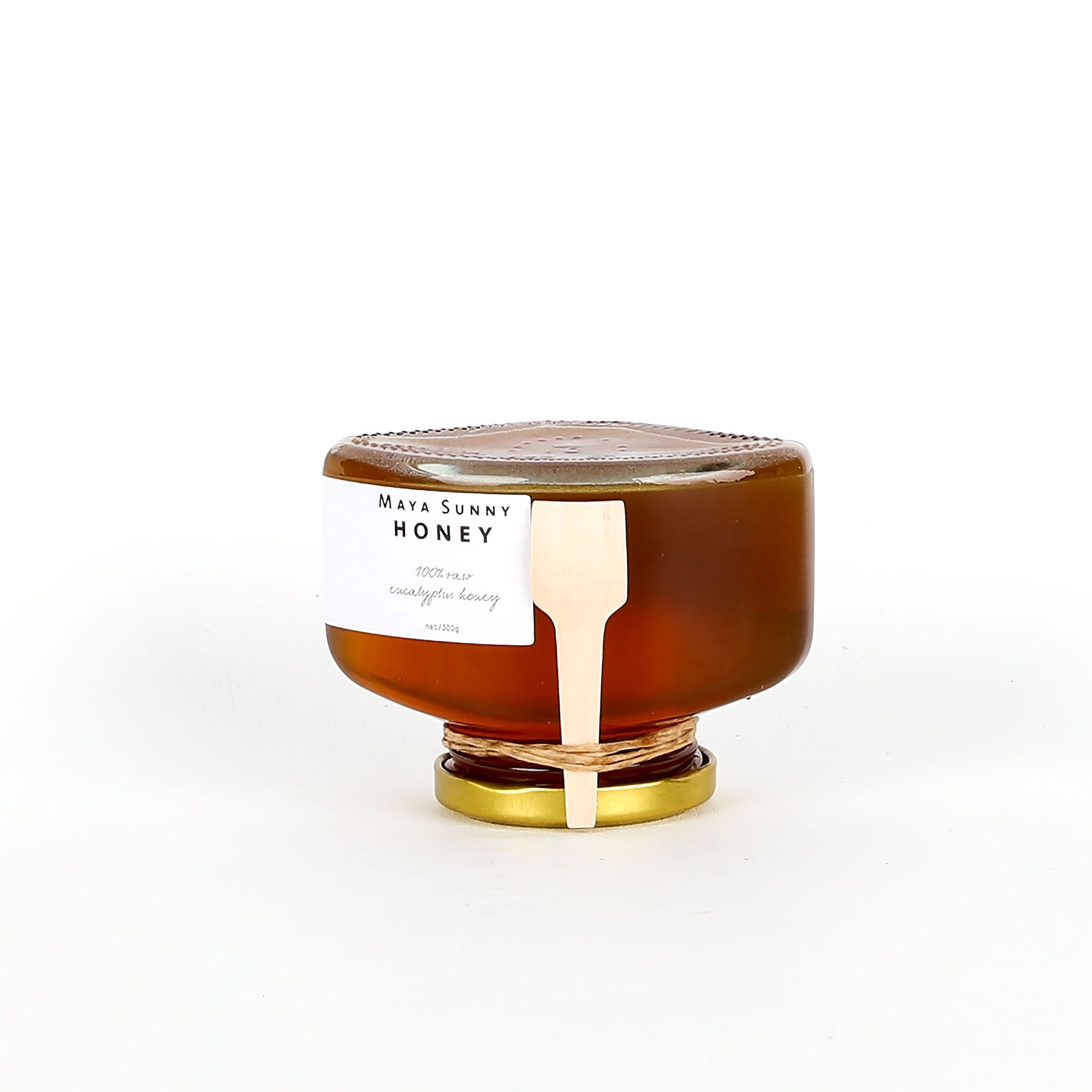 Jar of honey with a gold lid on a white background