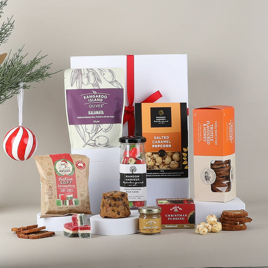 Assorted food items including olives, popcorn, and cookies displayed in front of a gift box.