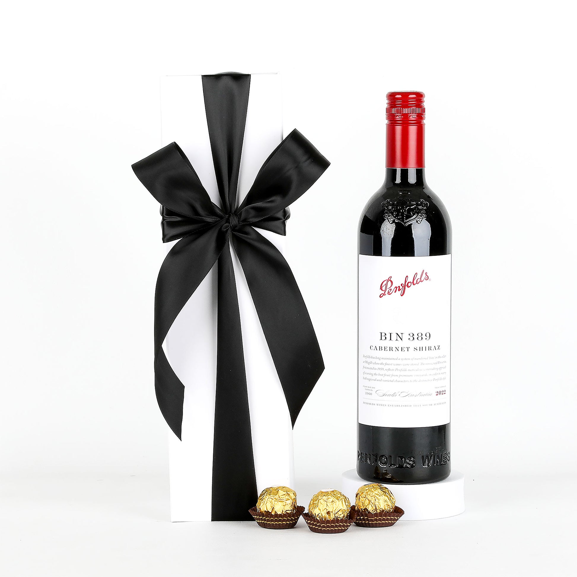 Penfolds BIN 389 Cabernet Sauvignon wine bottle with chocolates, white box & black ribbon on a white background