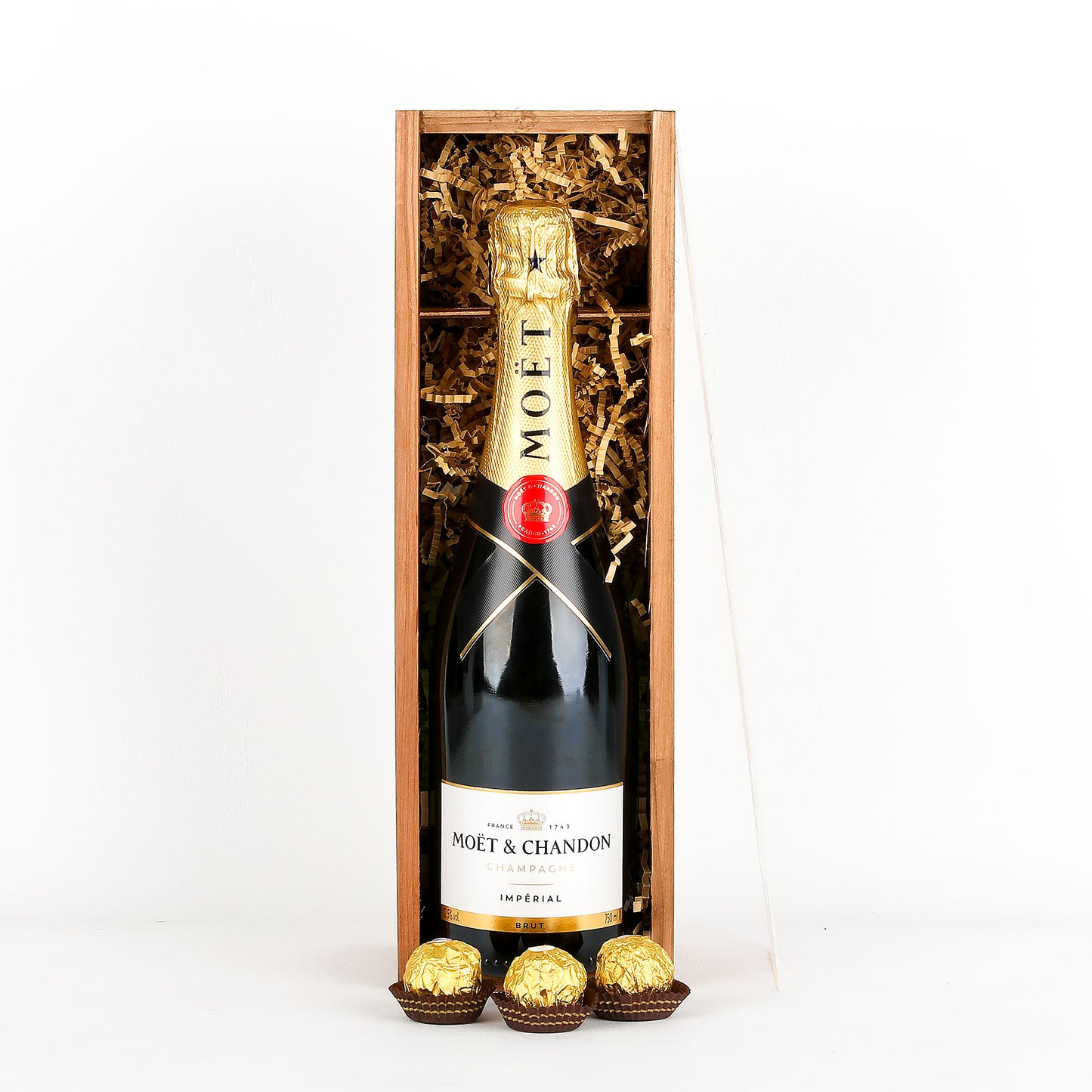 Moët & Chandon champagne bottle in a wooden gift box with chocolates on a white background
