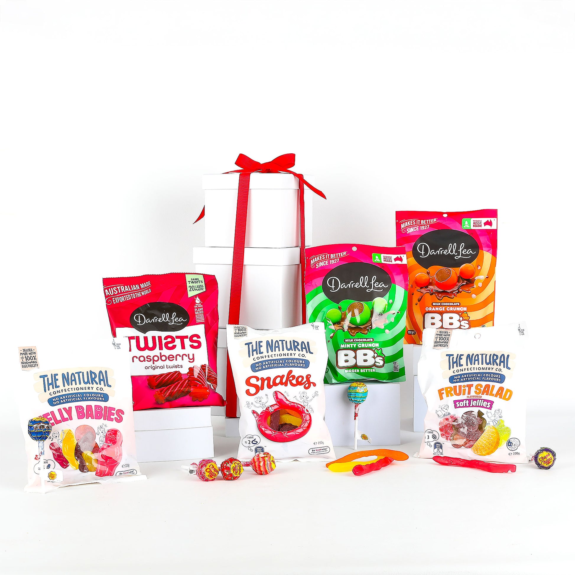 White boxes with chewy lollies, fruity jellies, and crunchy chocolate bites standing in front of them