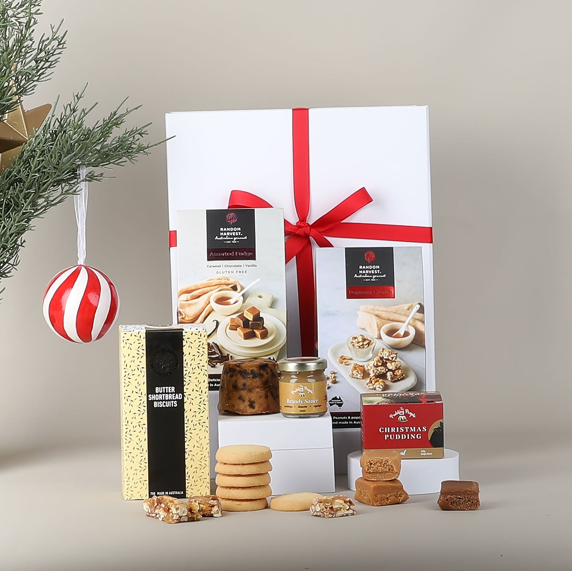Gift set with cookies, Christmas pudding, and other treats on a neutral background.