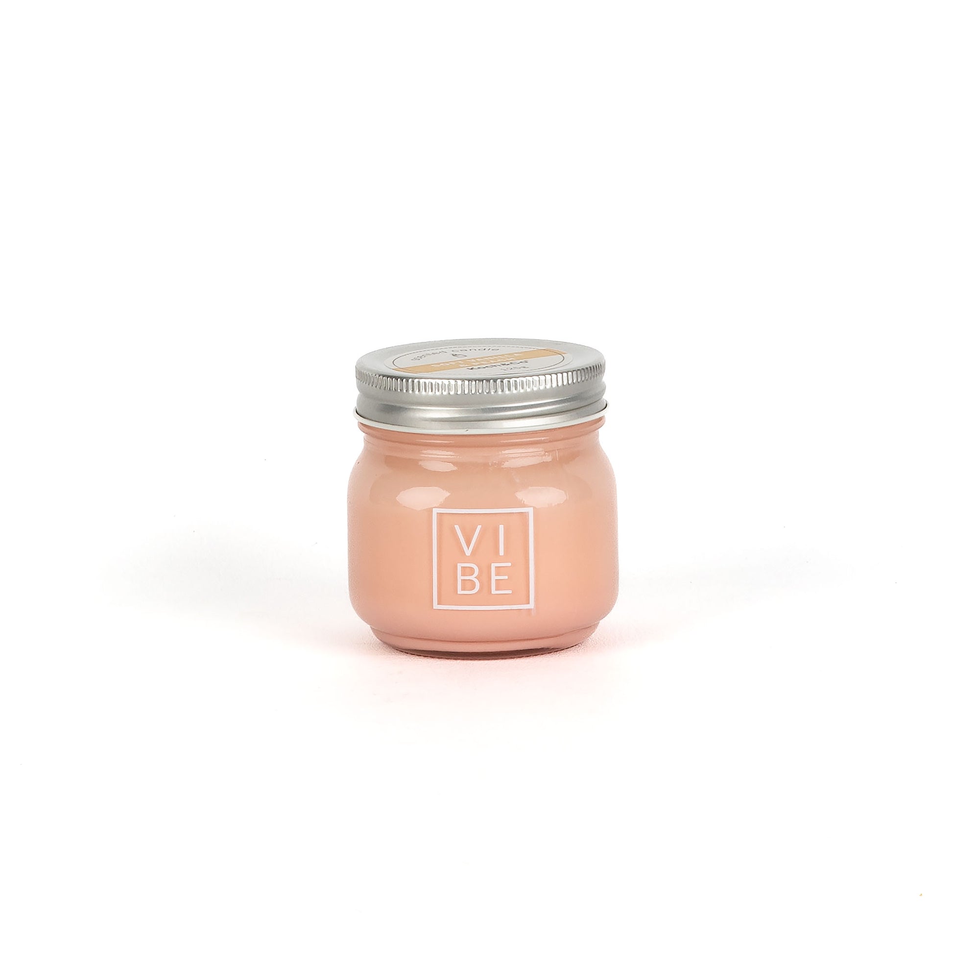 Pink candle in a glass jar with a metal lid on a white background, featuring the brand 'Vibe'.