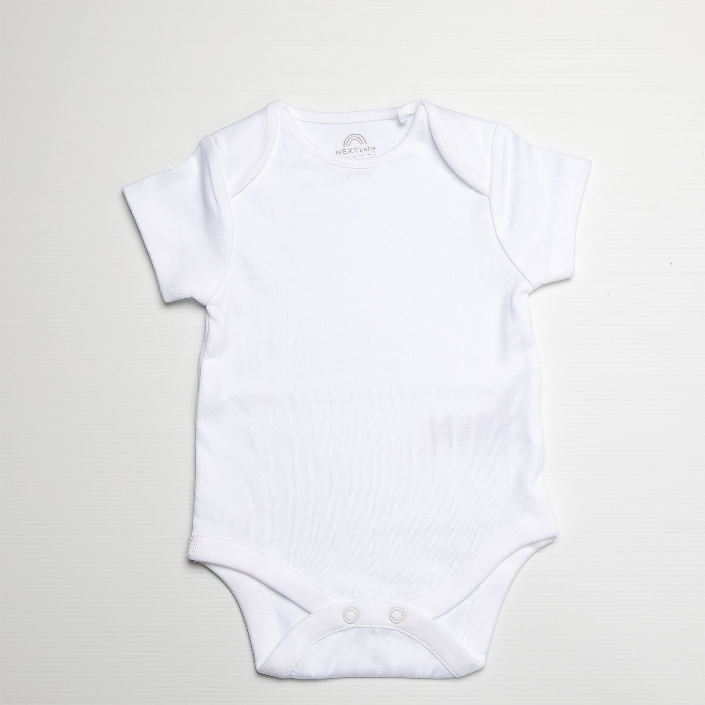 White baby onesie on a light gray background